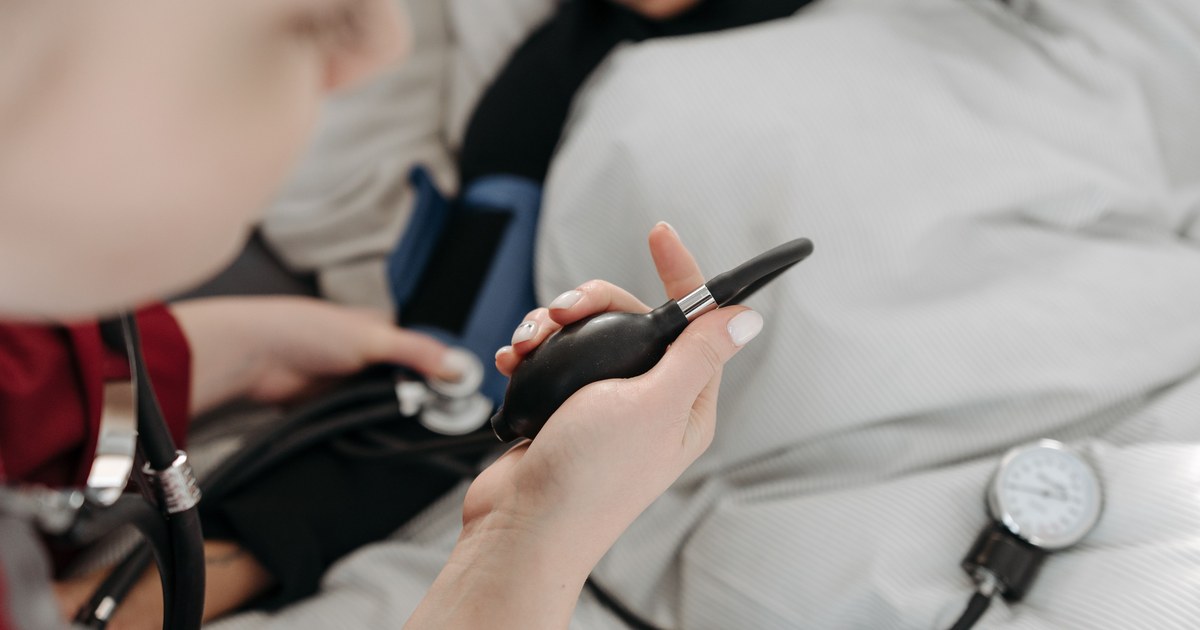 Nurse checking a bedbound patient's vitals at home