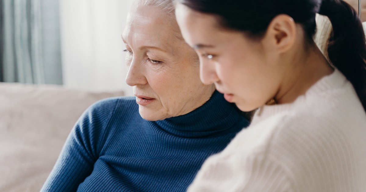 Adult daughter spending time with her mother who has dementia at home