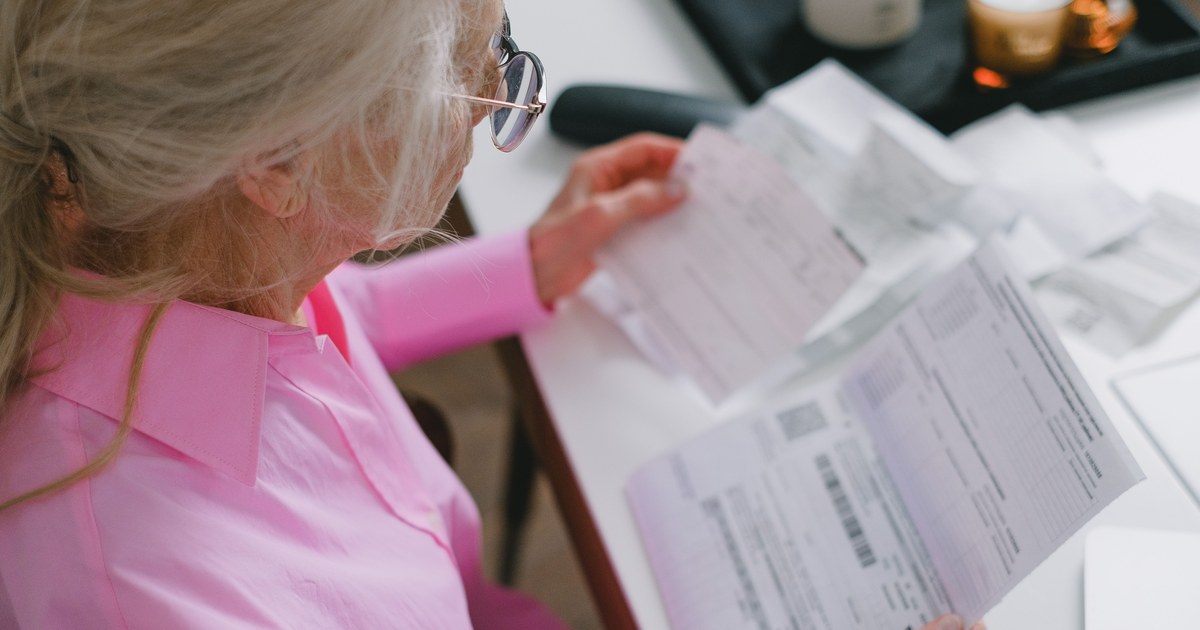 Older adult reviewing medical bills and paperwork at home