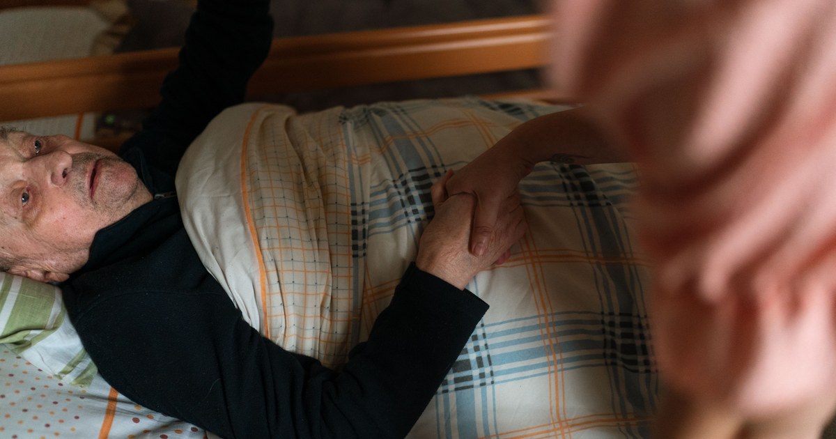 Caregiver holding hands with a senior patient at home
