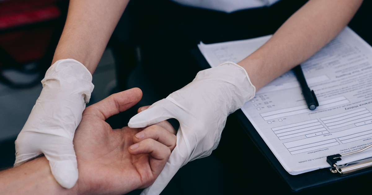 Healthcare worker examining a patient's hand and skin