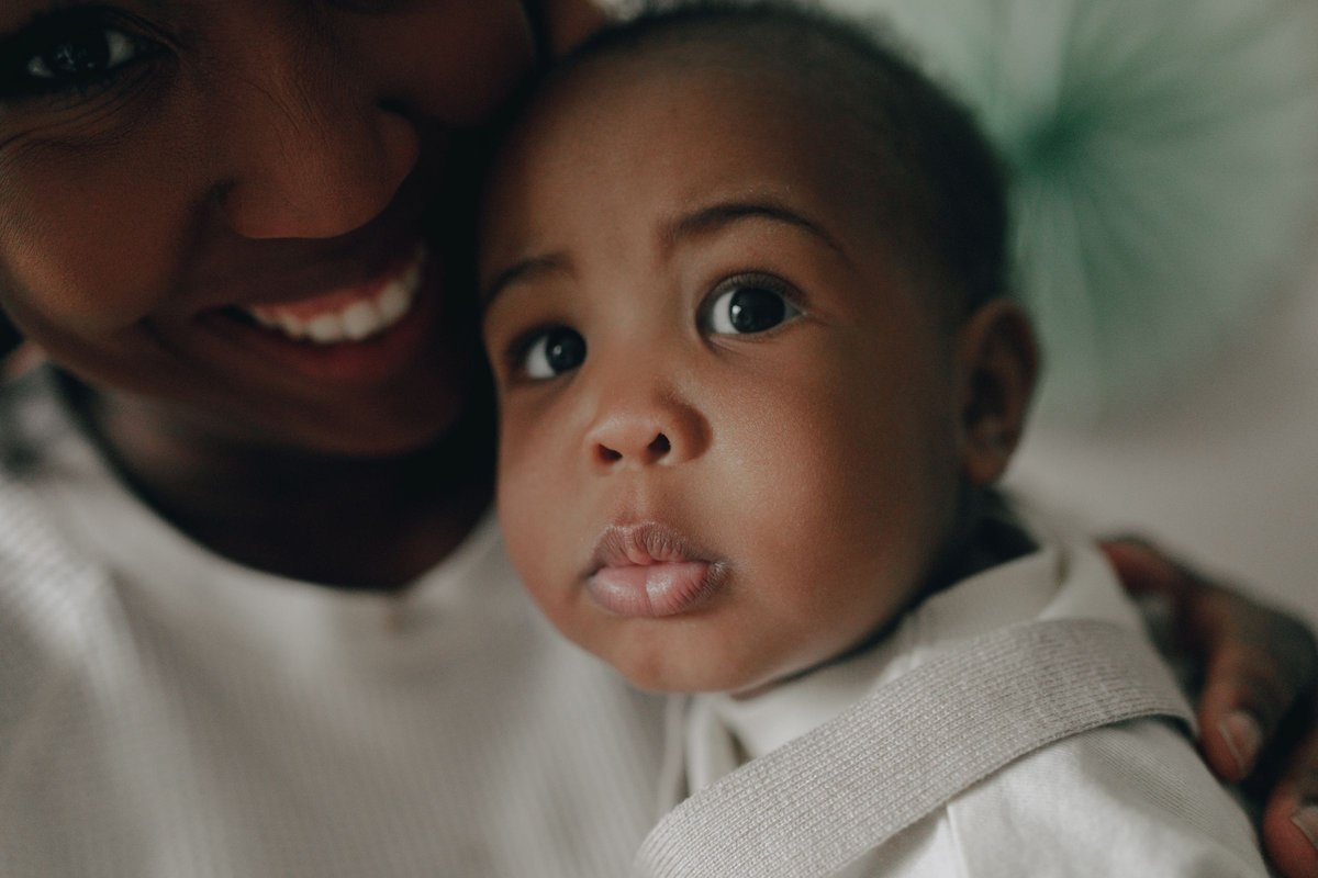 Smiling mother holding her baby close, face to face, at home
