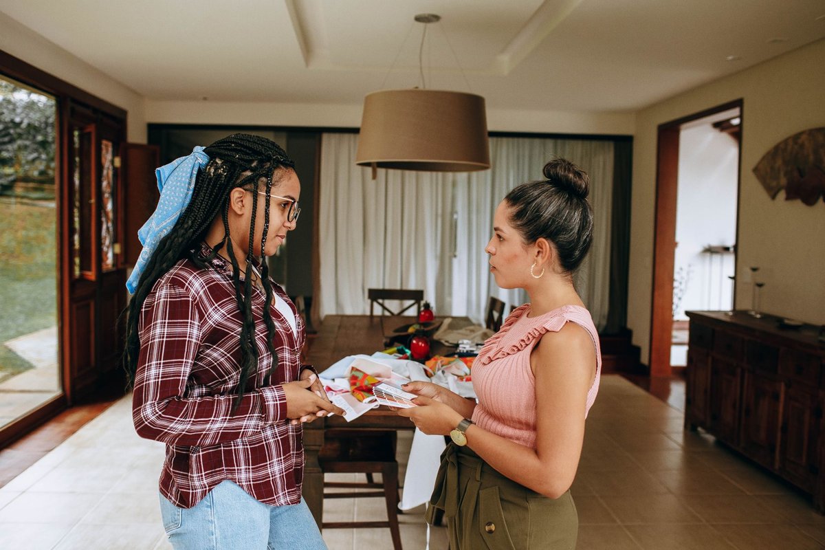 Two women talking face to face in a bright dining room