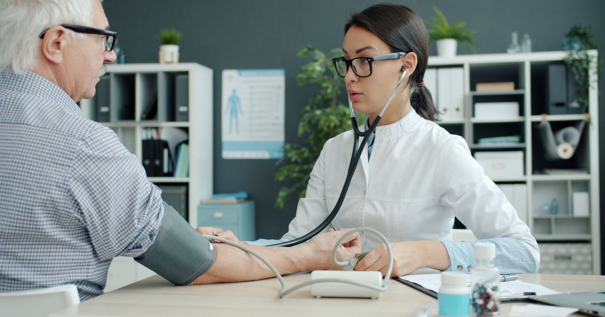 Doctor checking an older man's blood pressure during an appointment