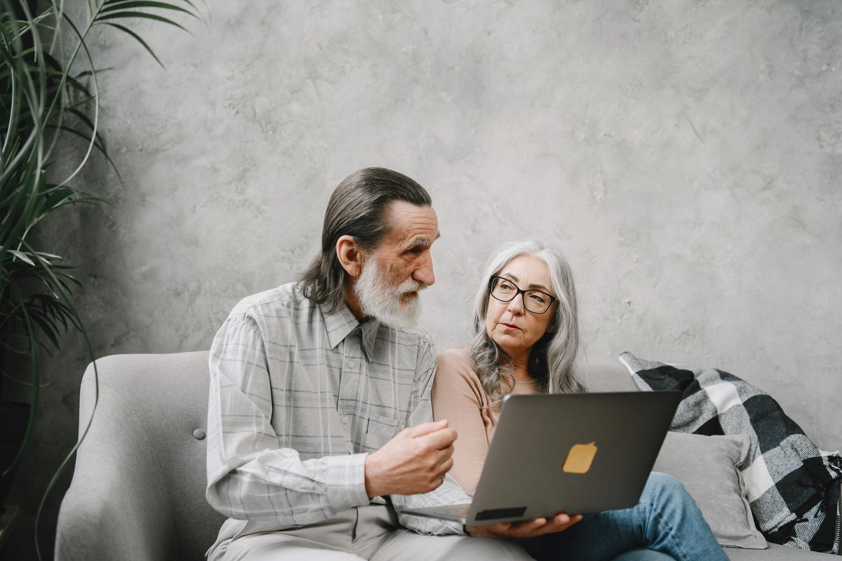 Older couple on a sofa looking at a laptop together