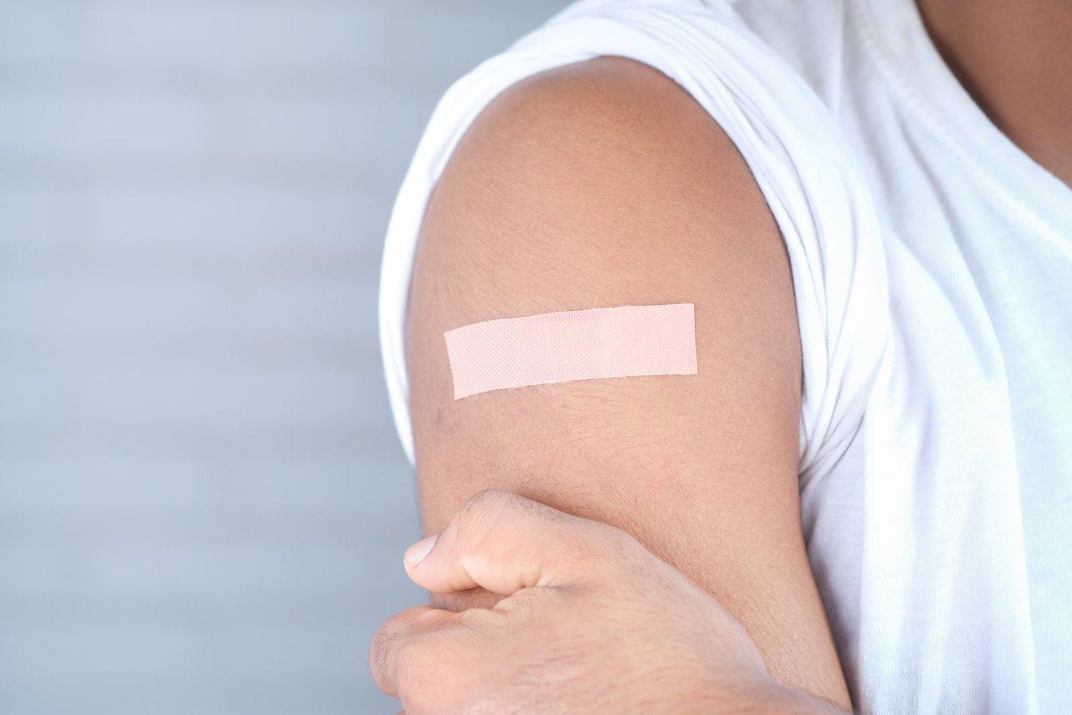Close-up of a bandage on the upper arm of a person after a vaccination